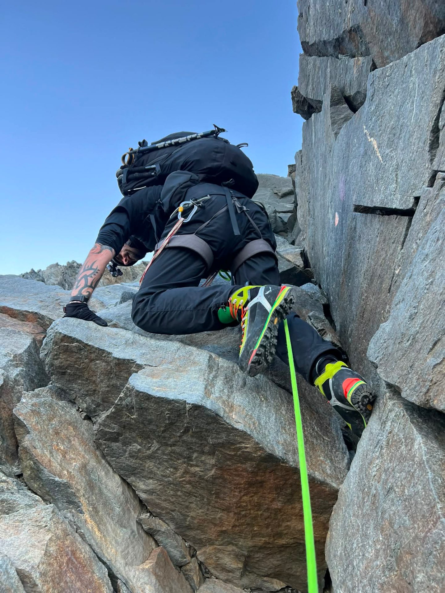 Danny Tolhurst moving across steep rock, roped up.